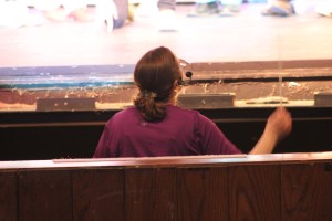 Ms. Winnie appearing from the pit to conduct the orchestra and performers